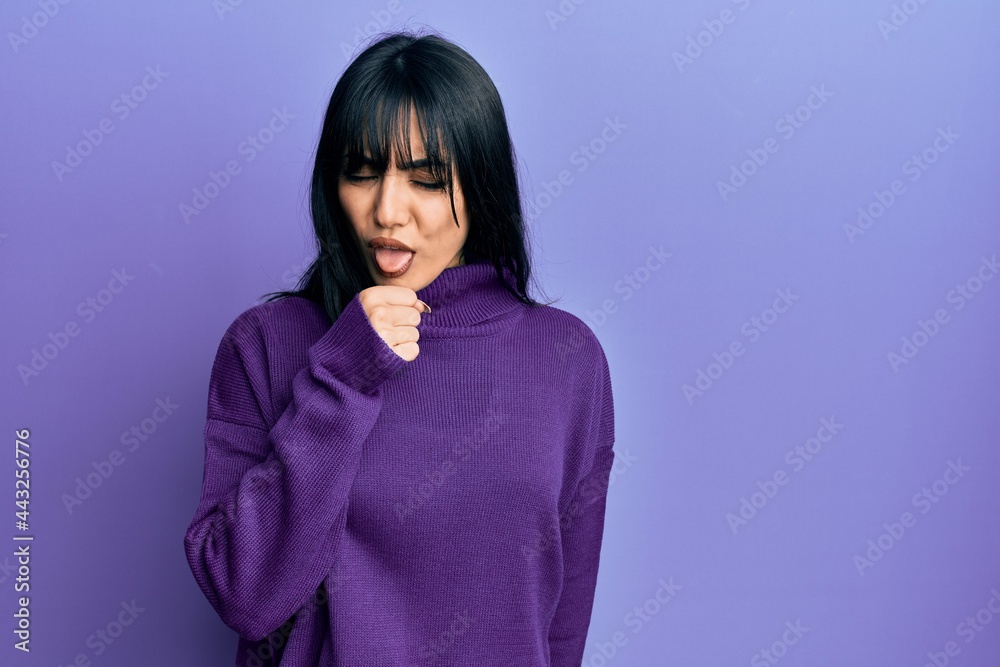 Young brunette woman with bangs wearing turtleneck sweater feeling unwell and coughing as symptom for cold or bronchitis. health care concept.