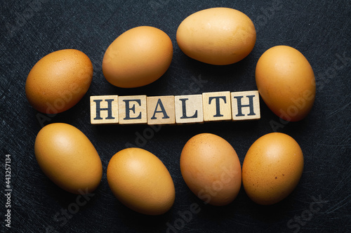 Egg with brown shell put beside Health word wood block