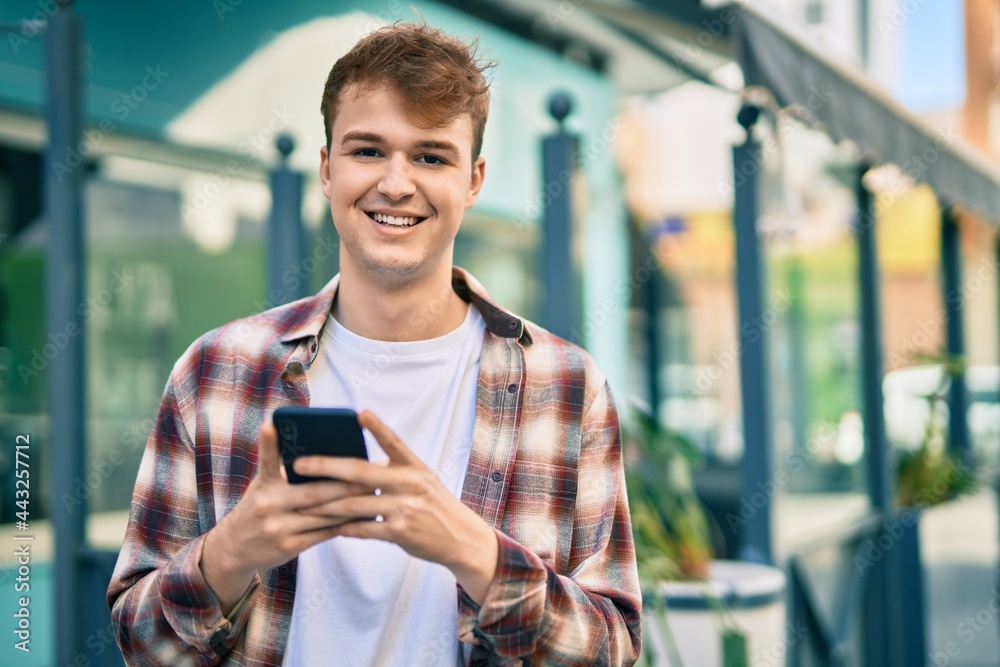 Young caucasian man smiling happy using smartphone at the city. Young caucasian man smiling happy using smartphone at the city.