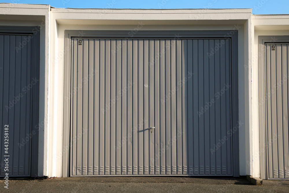 close up of a blue closed garage door in a parking area close up of a blue closed garage door in a parking area