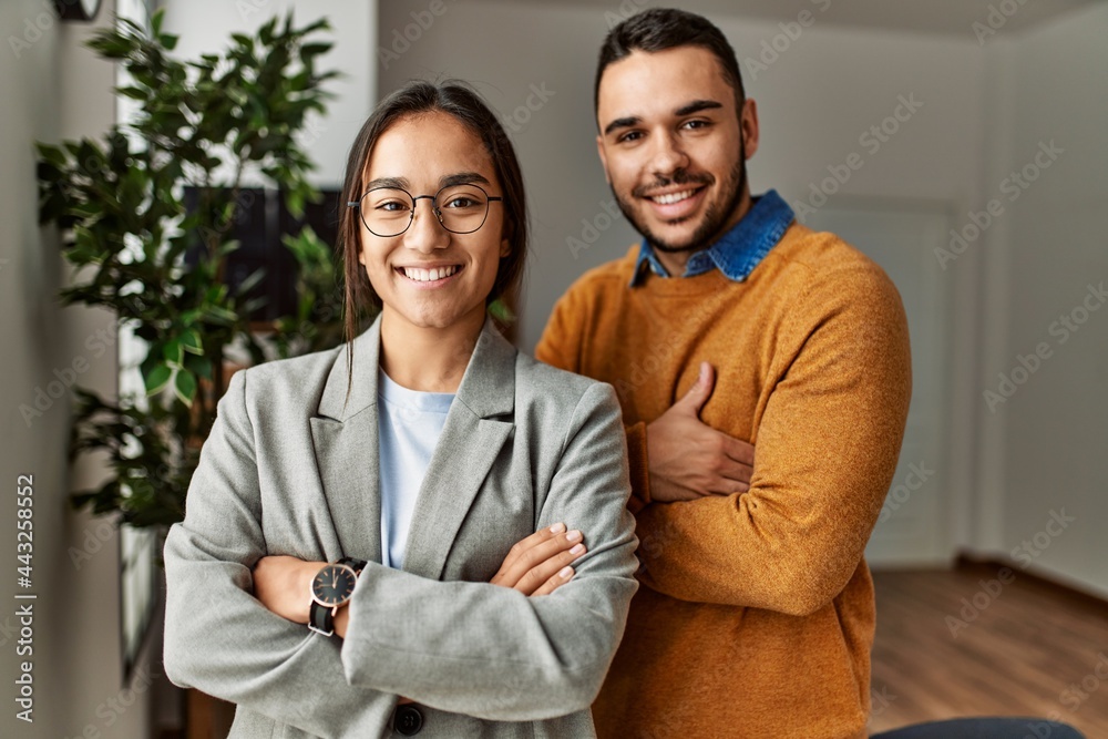 Two business workers smiling happy standing with arms crossed gesture at the office. Two business workers smiling happy standing with arms crossed gesture at the office.