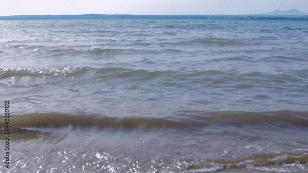 Blue sea water view from the coast. View of the water surface from the beach. Background of the water surface at the sunset Blue sea water view from the coast. View of the water surface from the beach. Background of the water surface at the sunset