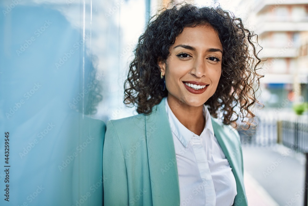 Young hispanic business woman wearing professional look smiling confident at the city leaning on the wall - obrazy, fototapety, plakaty 