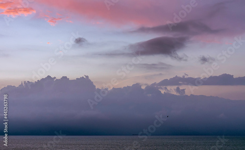 Violet sunset with cloud figures on the horizon.