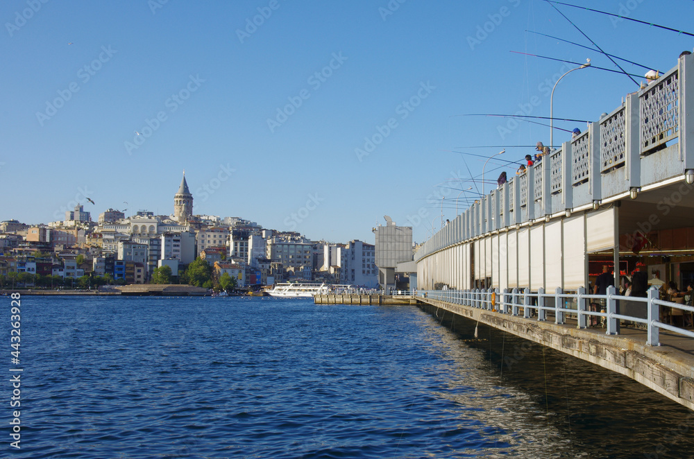 Bosphorus Bridge: fishermen with fishing rods, in the background the Galata Tower, Istanbul, Turkey