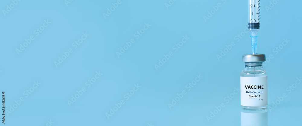 Vaccine in a bottle with a syringe on a blue background.The concept of medicine, healthcare and science.Coronavirus vaccine.Copy space for text.Banner Vaccine in a bottle with a syringe on a blue background.The concept of medicine, healthcare and science.Coronavirus vaccine.Copy space for text.Banner