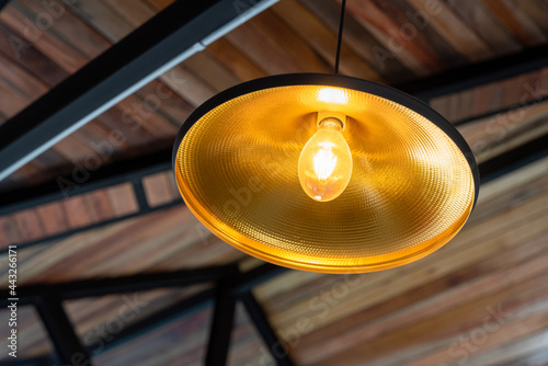 warm light bulb in structure under the roof is decorated with wood at building site of a house