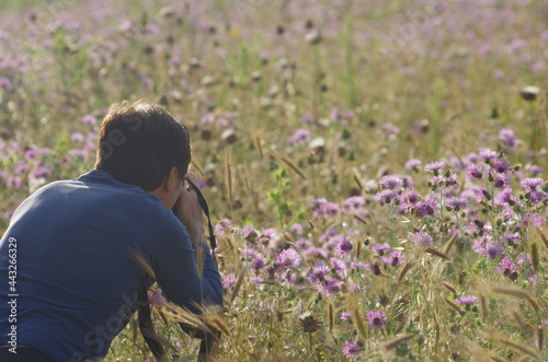 A photographer takes a scene with flowers