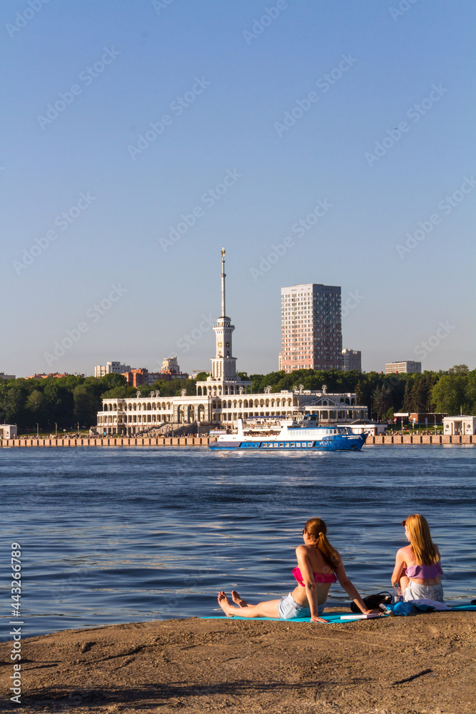 Two girls staring at North River Terminal (Severny Rechnoy Vokzal). Summer leisure in Moscow