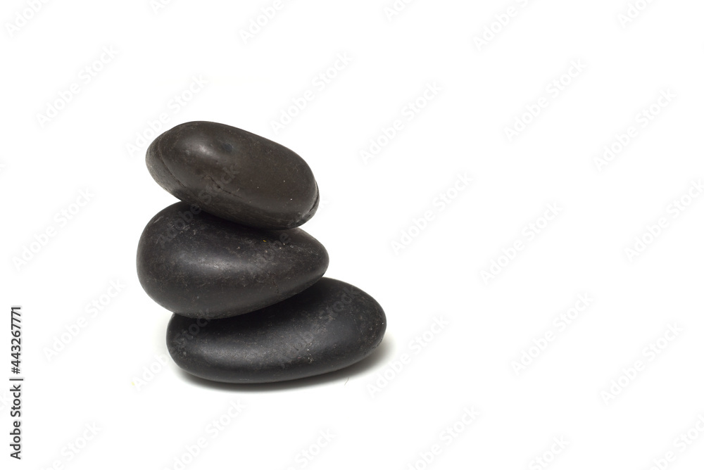 Closeup of black pebbles balance on white background Closeup of black pebbles balance on white background
