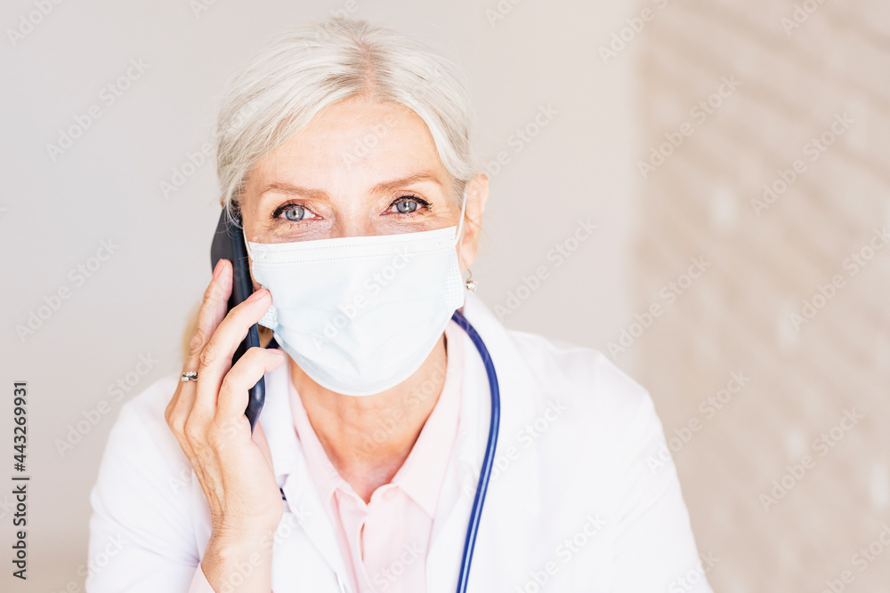 Female doctor portrait while wearing face mask and working at the doctor's office