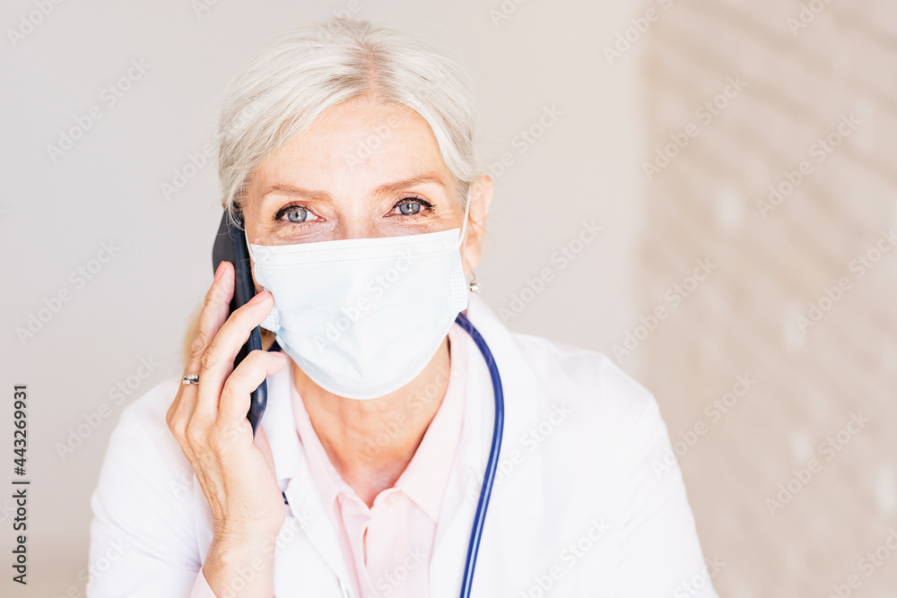 Female doctor portrait while wearing face mask and working at the doctor's office Female doctor portrait while wearing face mask and working at the doctor's office