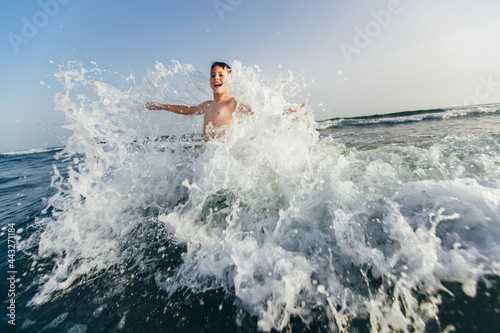 Happy child playing in the sea. Kid having fun outdoors. Summer vacation and healthy lifestyle concept. Selective focus © Mediteraneo