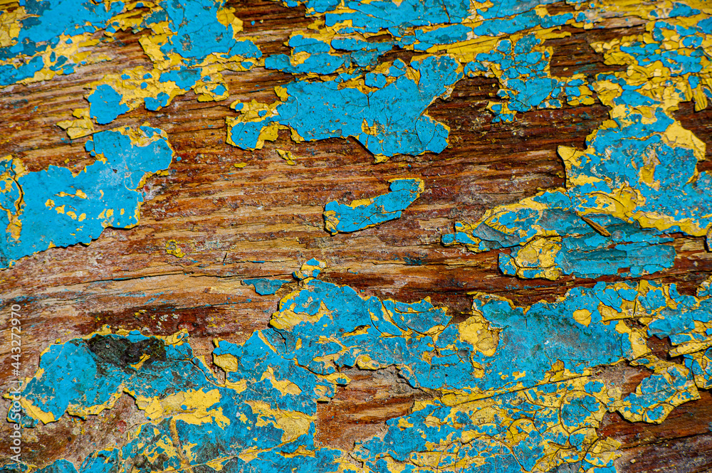 Collapsing old paint in yellow and blue on the wooden surface of the board. Web banner. Collapsing old paint in yellow and blue on the wooden surface of the board. Web banner.