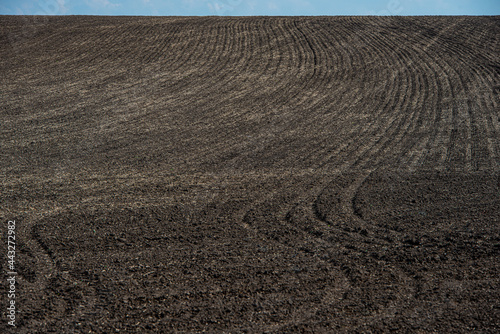 plowed field on a hillside, an agricultural field.