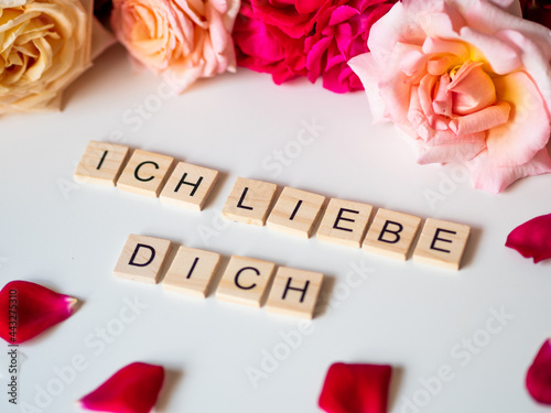 ICH LIEBE DICH - napis z drewnianych kostek, róże w tle, różowy kolor, język niemiecki 