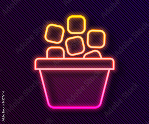 Glowing neon line Ice bucket filled with ice cubes icon isolated on black background. Vector
