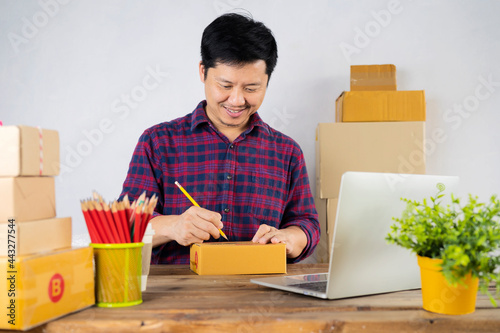 Parcel box on desk with man making notes in the back.