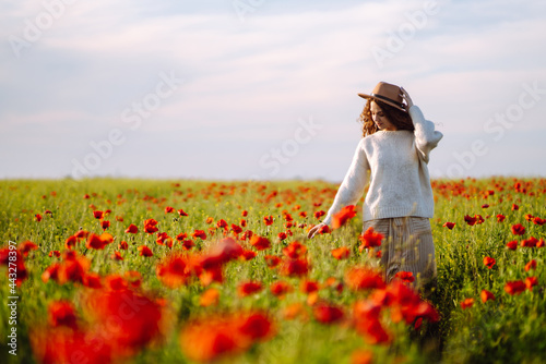 Beautiful woman in a blooming poppy field. People  lifestyle  travel  nature and vacations concept.