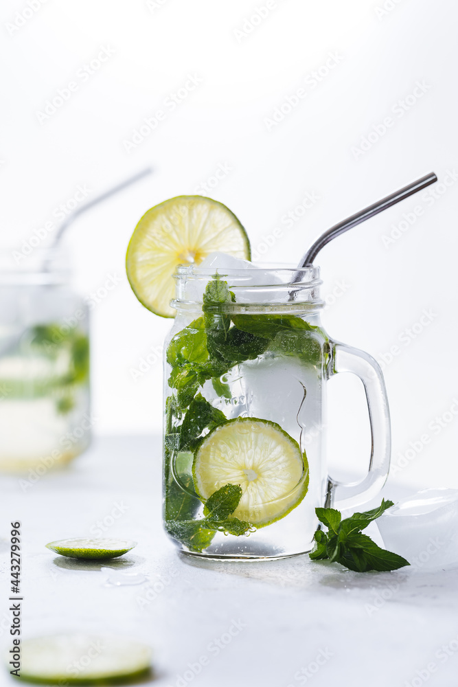 Fototapeta premium Mojito cocktails served on a bright background with lime and straw