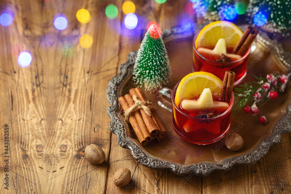 Christmas mulled red wine with spices and Christmas decorations on wooden table. Happy holidays greeting card.