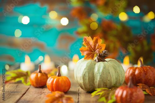 Happy Thanksgiving concept pumpkin decor on wooden table over festive background. Autumn season greeting card.