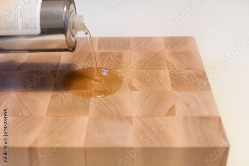 Auftragen von Holzpflegeöl auf ein Lebensmittelschneidebrett. Applying wood care oil on a food cutting board.