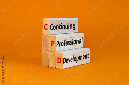 CPD, continuing professional development symbol. Wooden blocks with words CPD, continuing professional development on beautiful orange background. Business, CPD concept. photo