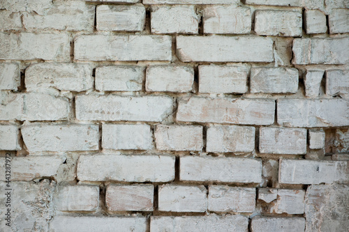 Abstract old white brick wall. background facade brick wall black and white. Vintage old brick wall texture. Grunge stone wall horizontal background. Dilapidated building facade with damaged plaster.