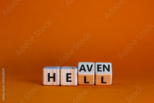 Hell or heaven symbol. Turned wooden cubes and changed the word 'hell' to 'heaven'. Business and religion concept. Beautiful orange background, copy space.