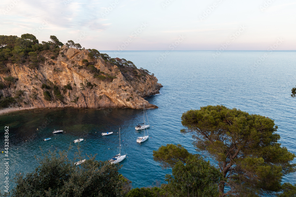 Remote and wild Mediterranean beach with boats