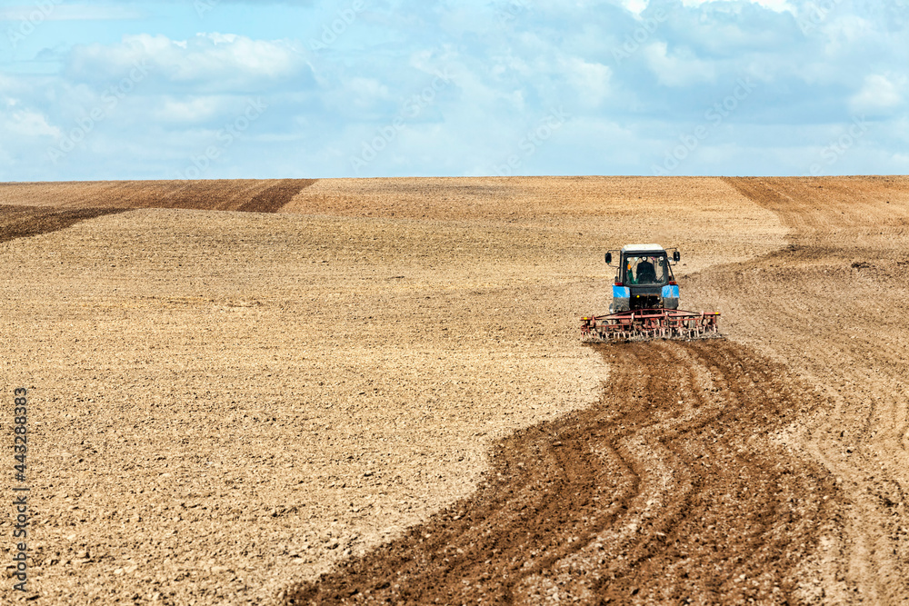 Obraz premium an old tractor plows the soil