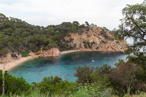 Remote and wild Mediterranean beach with boats