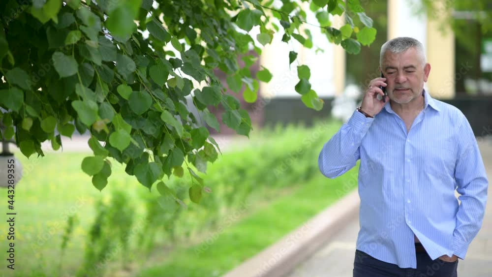 Portrait handsome businessman talking on smartphone at street. Cheerful man man walking with mobile phone at Outside.
Portrait handsome businessman talking on smartphone at street. Cheerful man man walking with mobile phone at Outside.