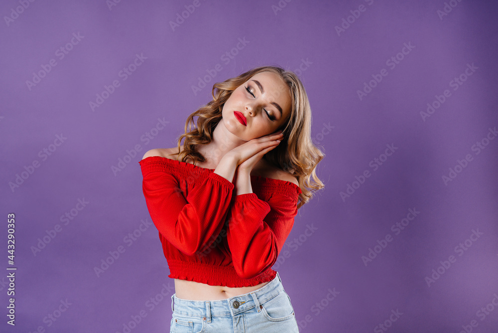 A young beautiful girl shows emotions and smiles in the Studio on a purple background. Girls for advertising A young beautiful girl shows emotions and smiles in the Studio on a purple background. Girls for advertising
