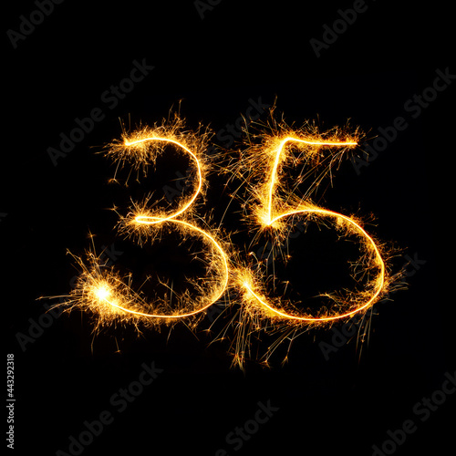 Sparkling number 35 isolated on black background photo