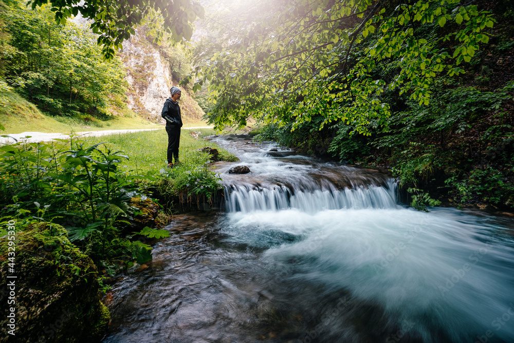 Man standing by waterfall in the forest Man standing by waterfall in the forest