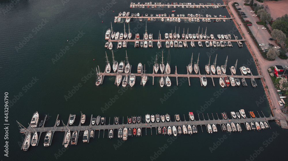 Aerial top view of a lot of white yachts and sailboats moored in a marina, summer season Aerial top view of a lot of white yachts and sailboats moored in a marina, summer season
