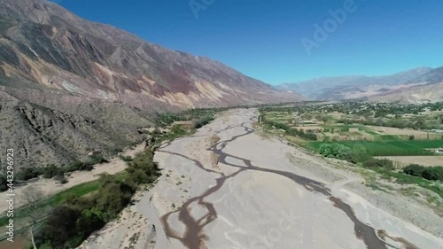 Sobrevolando un rio seco en jujuy argentina, con cultivos en sus laderas y bellos cerros de colores, tipicos de la region. photo