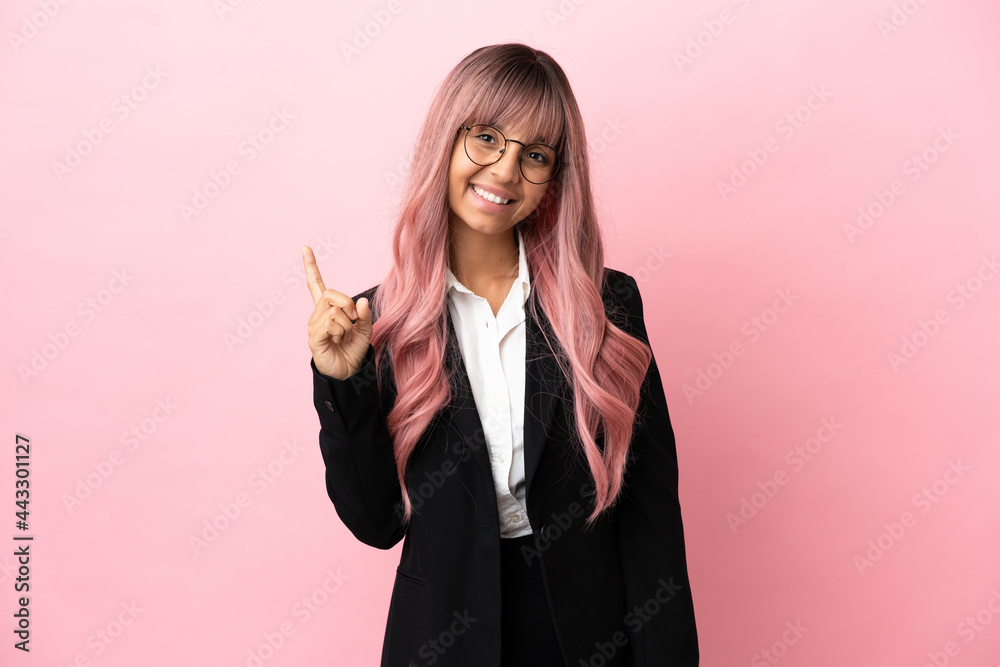Young business mixed race woman with pink hair isolated on pink background showing and lifting a finger in sign of the best Young business mixed race woman with pink hair isolated on pink background showing and lifting a finger in sign of the best