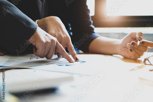 The company employee points to the budget document and makes marketing out of the budget being reviewed