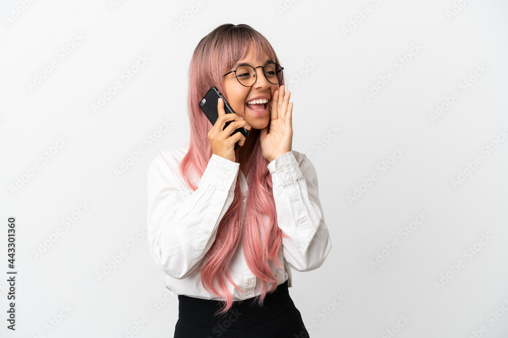 Young business mixed race woman with pink hair holding a mobile isolated on pink background shouting with mouth wide open to the side Young business mixed race woman with pink hair holding a mobile isolated on pink background shouting with mouth wide open to the side
