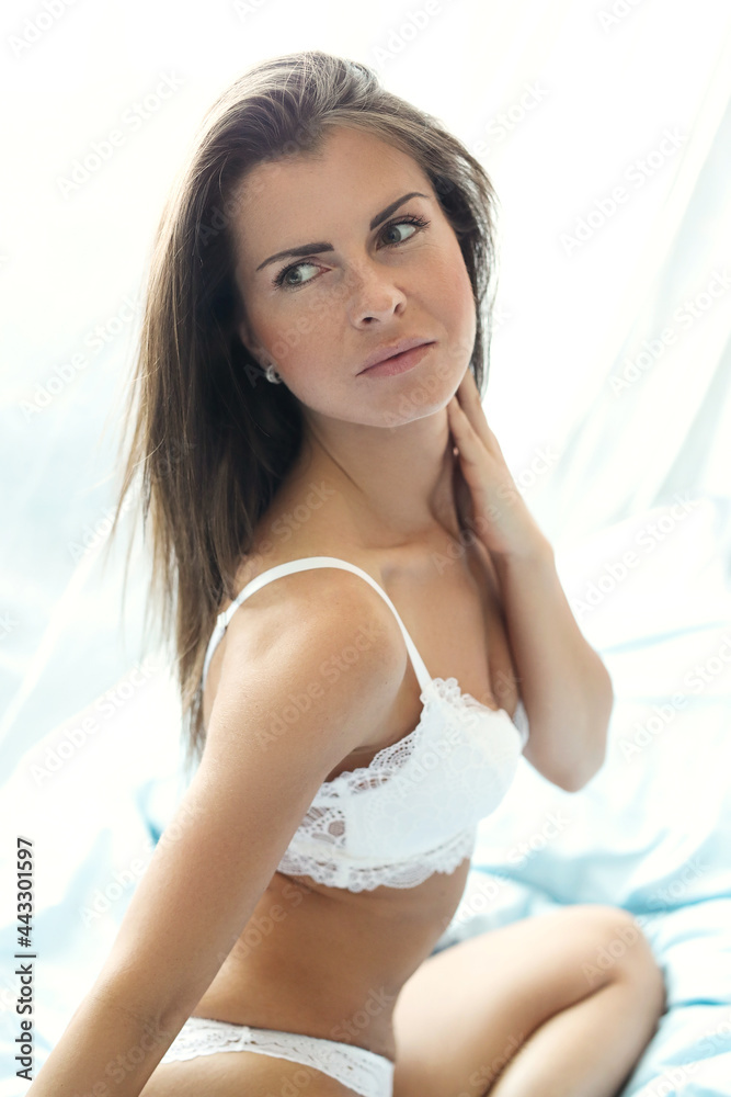 The blonde girl is doing a photo shoot at home, moving in bed in a night dress The blonde girl is doing a photo shoot at home, moving in bed in a night dress