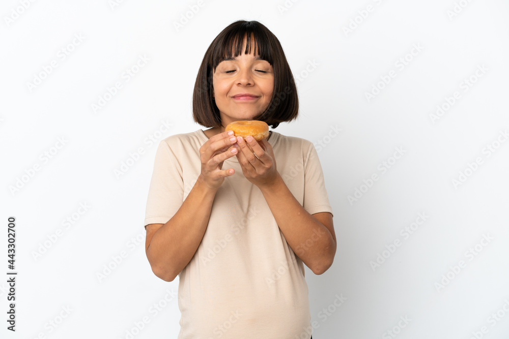 Young mixed race pregnant woman isolated on white background holding a donut