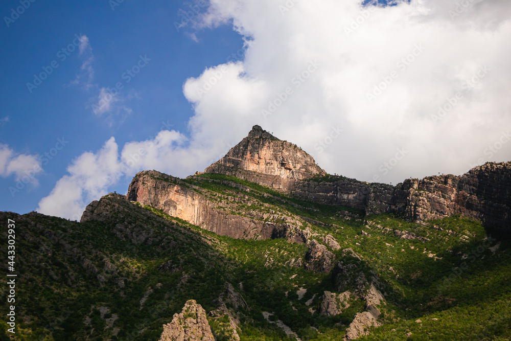 Pico de una montaña rocosa con nubes de fondo