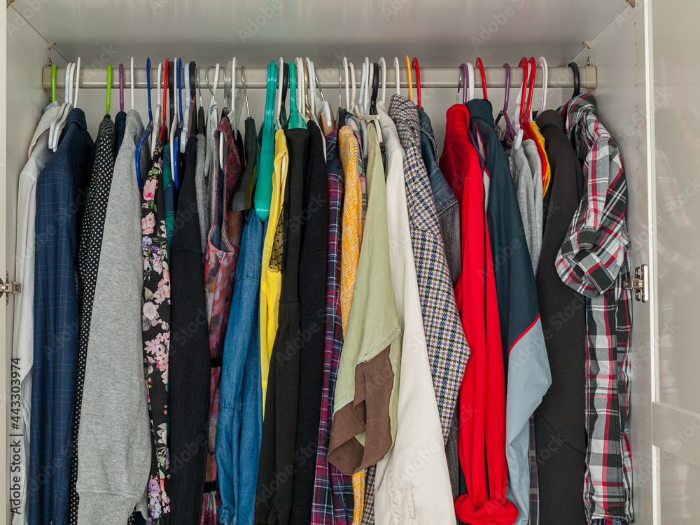 wardrobe with hanging clothes, filled wardrobe, storing clothes at home, saving space