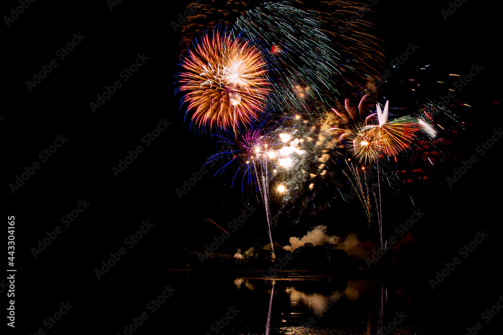 Holiday fireworks above water with reflection in the water Holiday fireworks above water with reflection in the water
