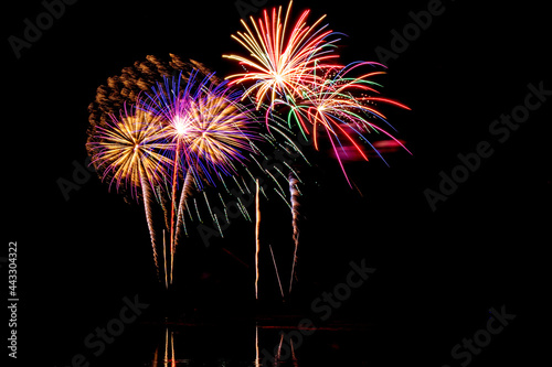 Holiday fireworks above water with reflection in the water