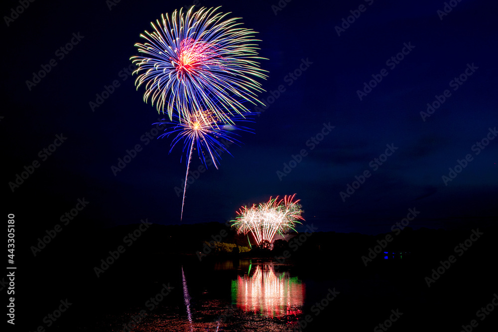 Holiday fireworks above water with reflection in the water Holiday fireworks above water with reflection in the water