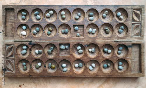 Antique Boa Mancala tradition African Board Game. Vintage Bao carved wooden Board Game. With natural baobab tree seeds Balls. photo